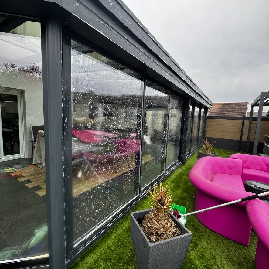 Lavage d’une vitre de véranda avec mousse pendant l’intervention